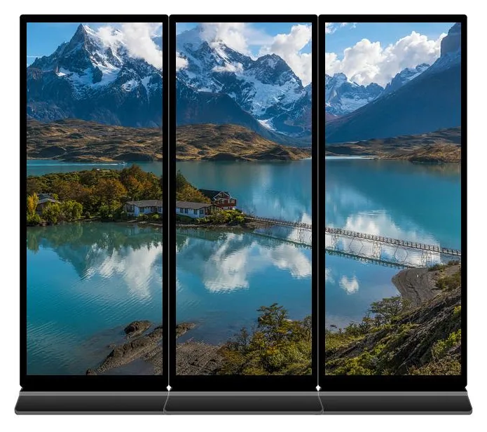 Three full-screen digital posters standing side by side with narrow bezels to show one continuous landscape picture