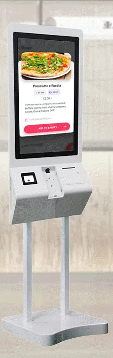 White freestanding ordering kiosk with a portrait touchscreen above an angled peripheral shelf, on twin poles over a contoured base